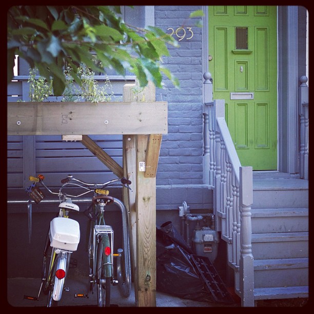 a bicycle is parked next to a house with a green door