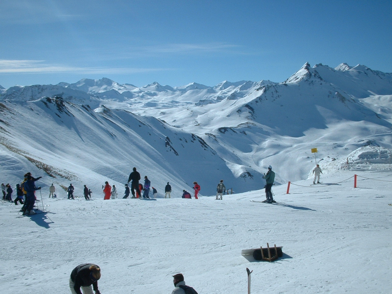 several people skiing on a ski slope with mountains in the background