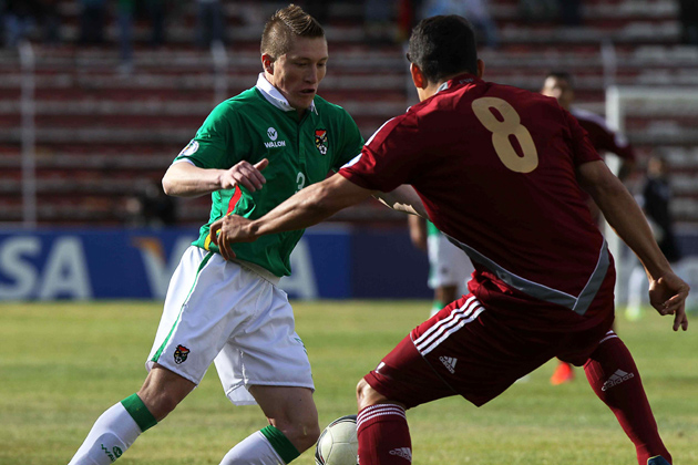 two soccer players fighting for the ball during a game