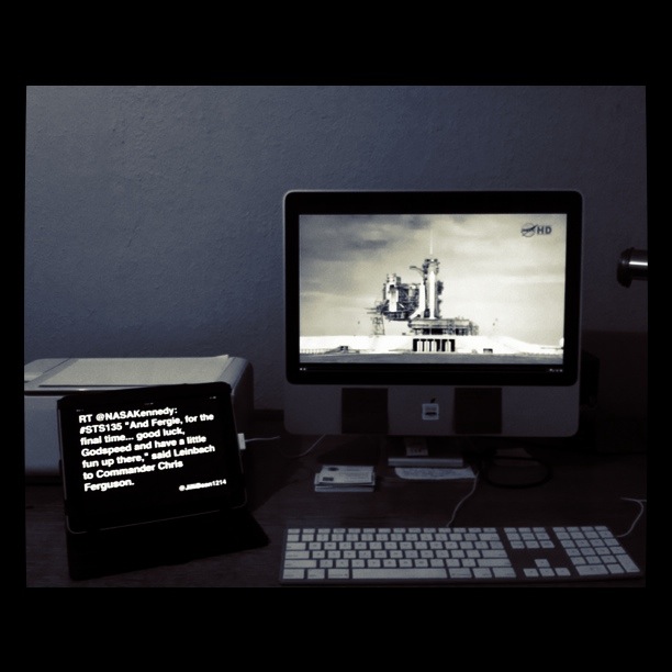 an apple computer on a desk with a monitor