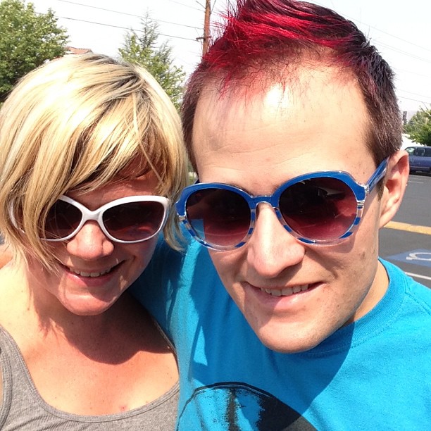 a man and woman with red hair and sunglasses on taking a picture