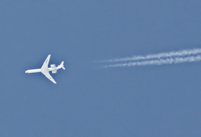 an airplane with contrails going straight in the sky