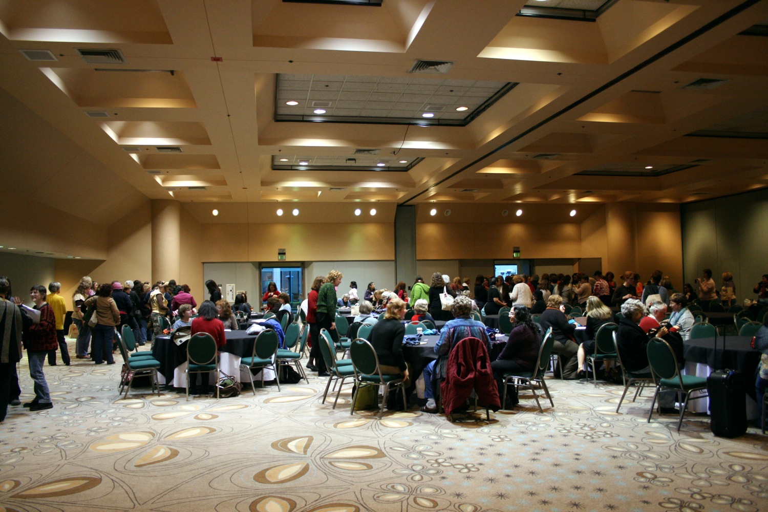 large group of people in a room with several chairs