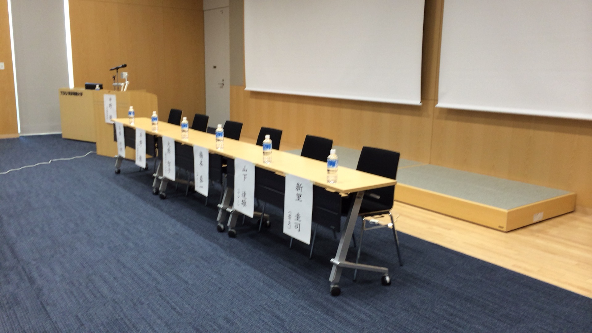 a long board room table with some bottles on the back