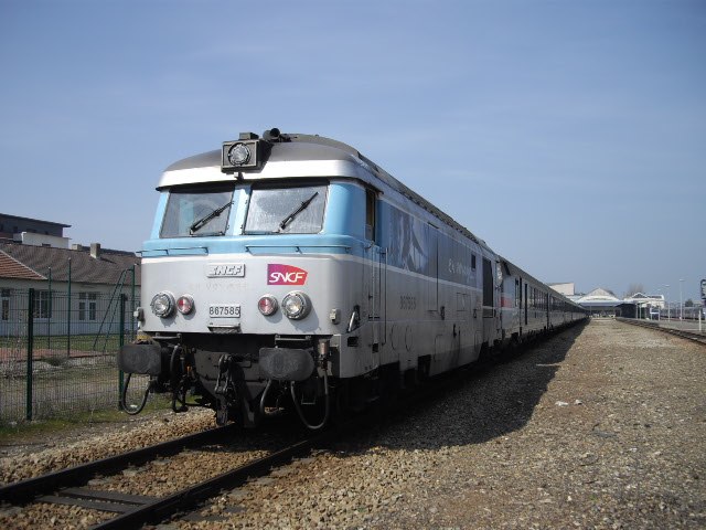 a commuter train sitting on the tracks, on the rails