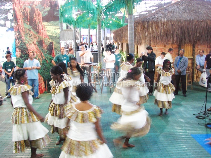 young women dance with hula skirts in front of a crowd