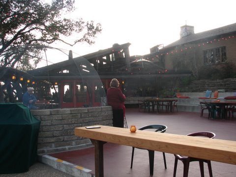 an outside courtyard that has people and some food on tables