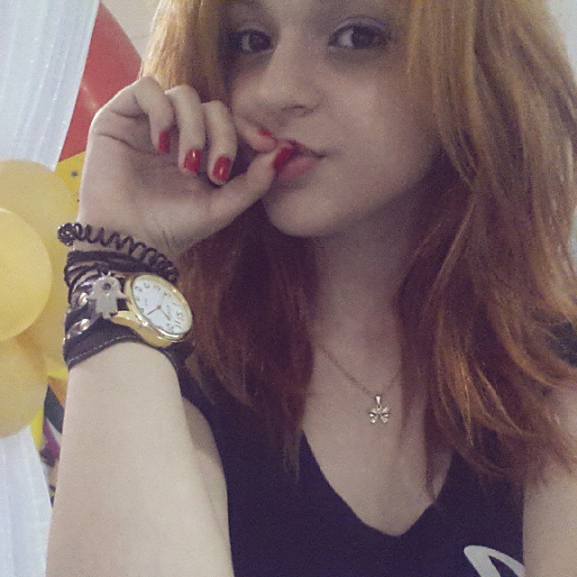 young asian woman with red hair and a watch on her left wrist