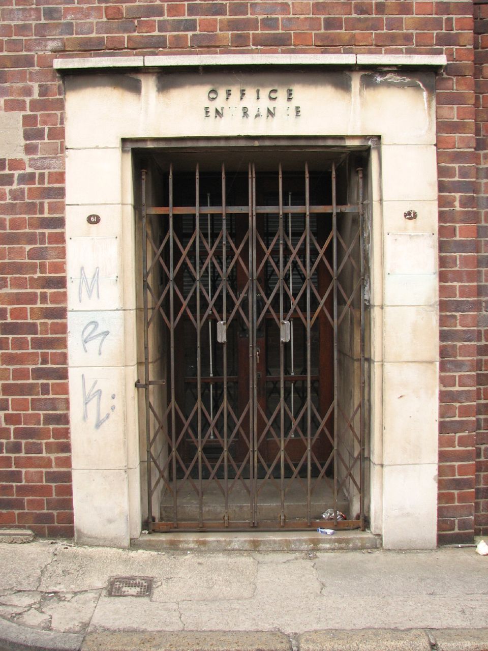 an iron gate that is on the side of a brick building