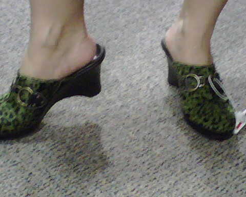 closeup of woman's feet and green shoe trims