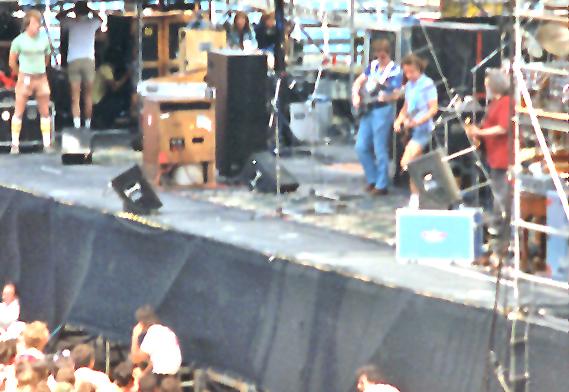 a band performing on stage during an outdoor concert