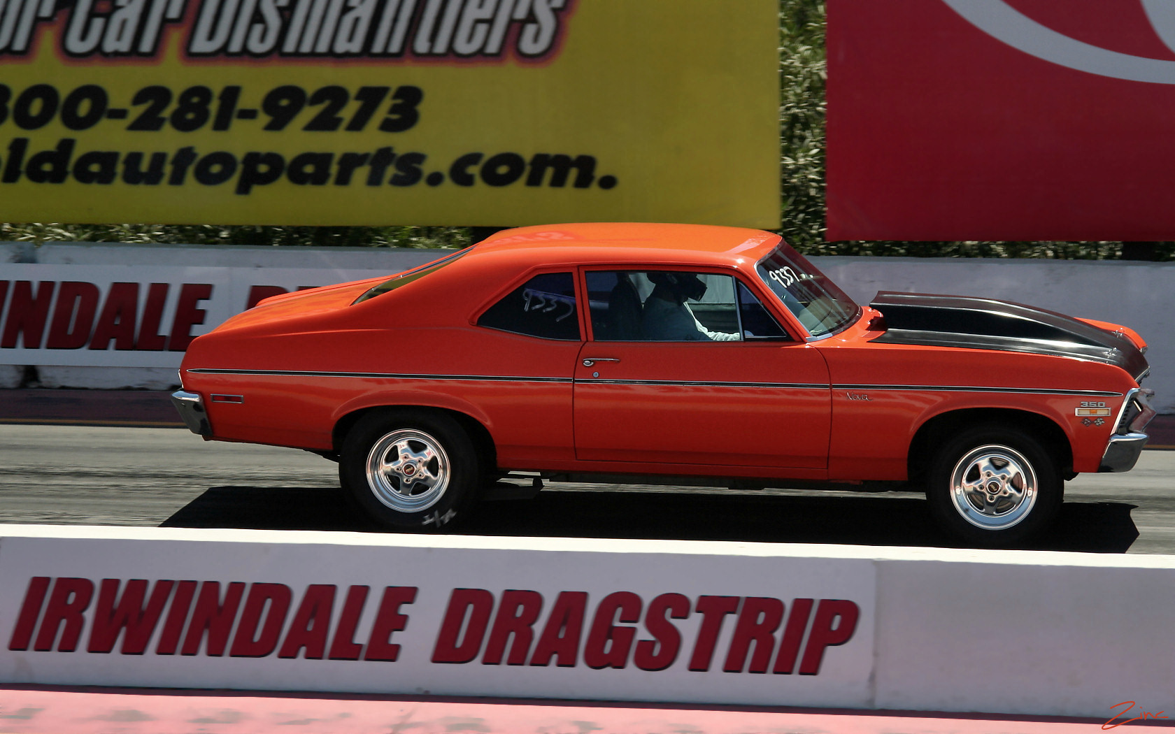 a large orange car on display on a parking lot