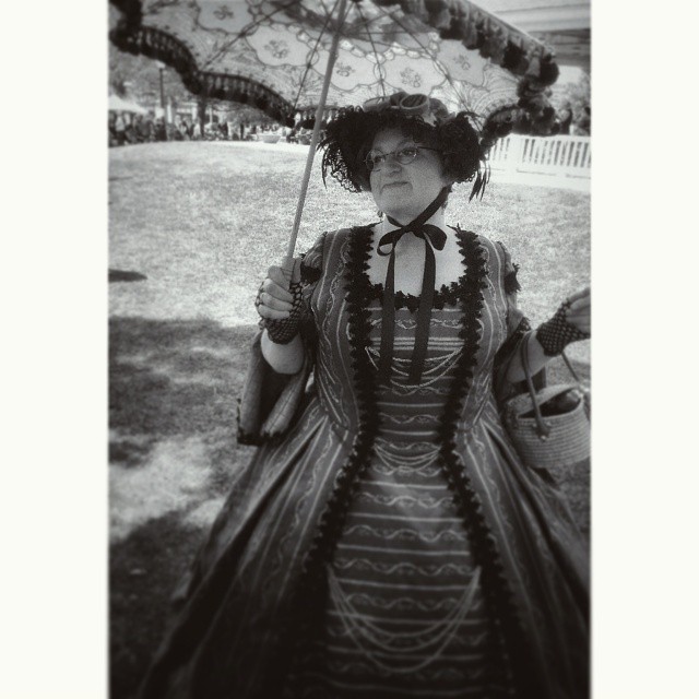 a woman dressed in black and white holds an umbrella