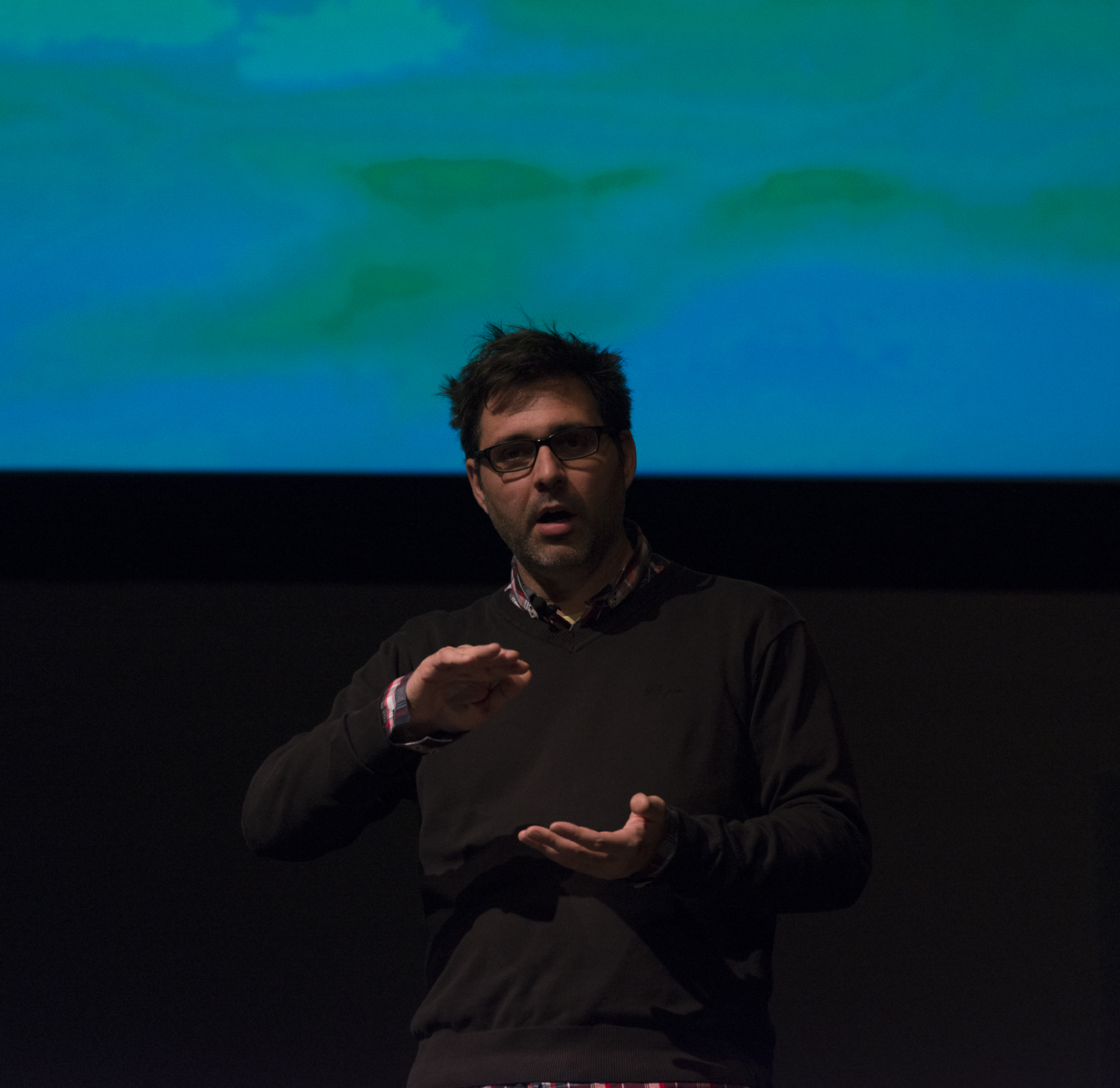 a man in black shirt giving a talk