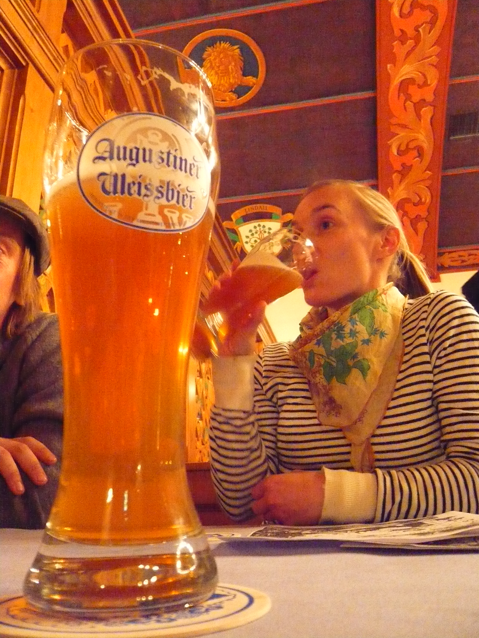 a woman and man sitting at a table with beer