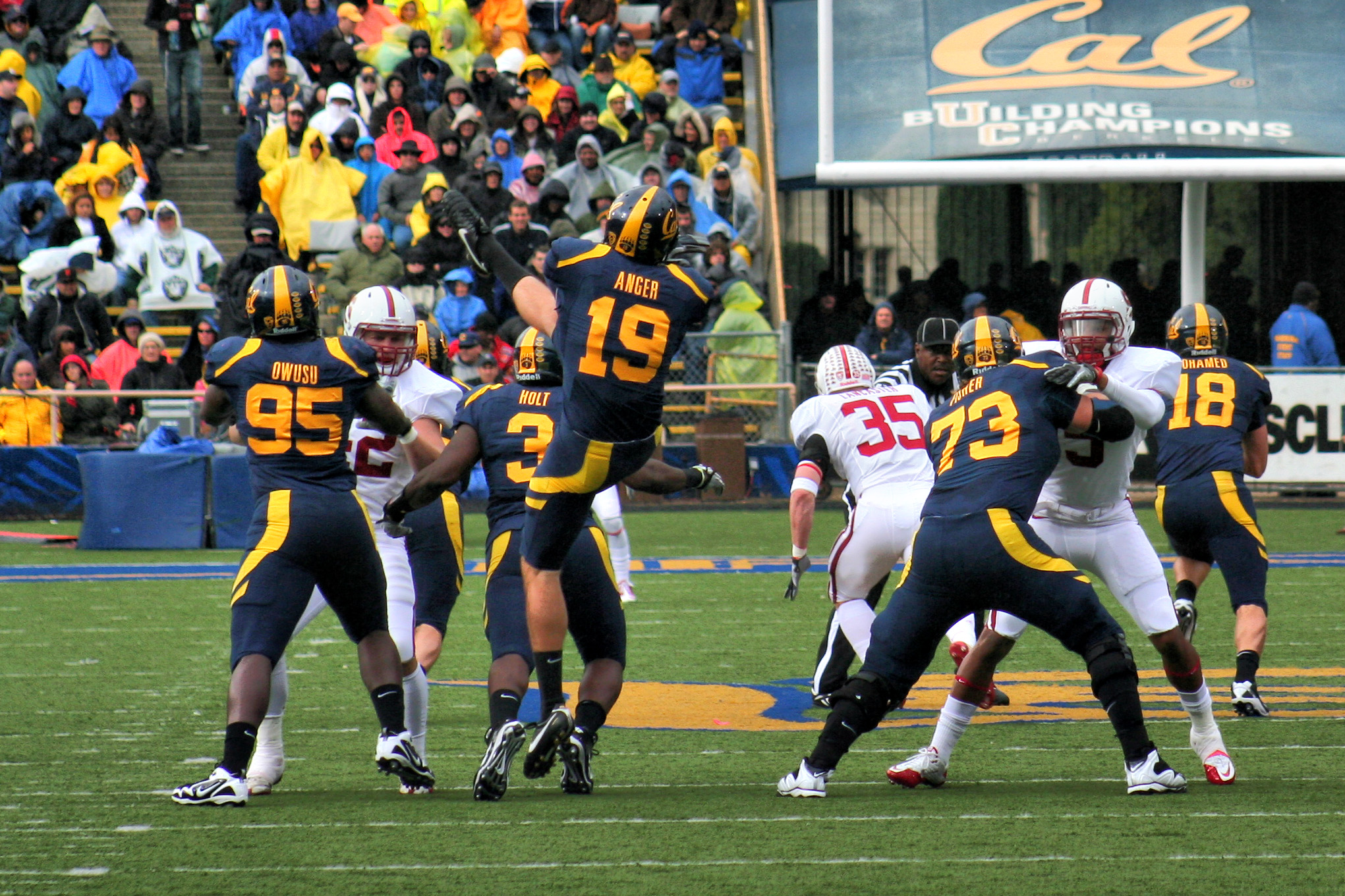 football players play on a field, while a crowd watches