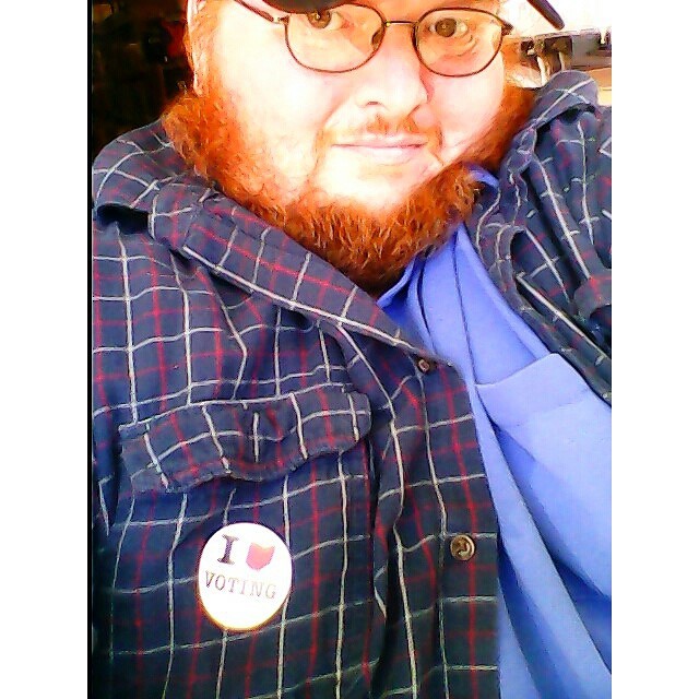 a man with glasses wearing a blue shirt with a on