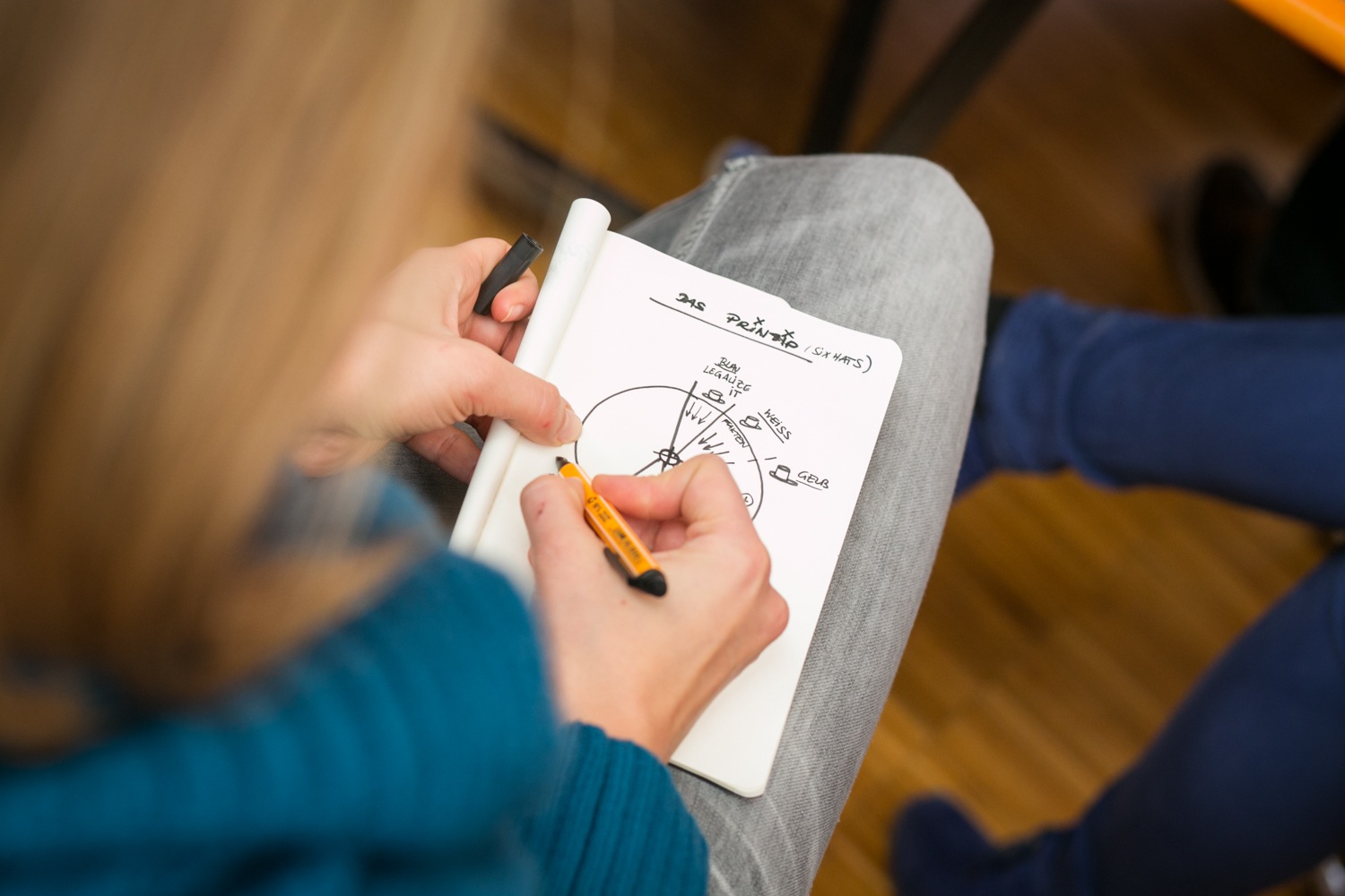 someone is writing on a notepad while holding a pen