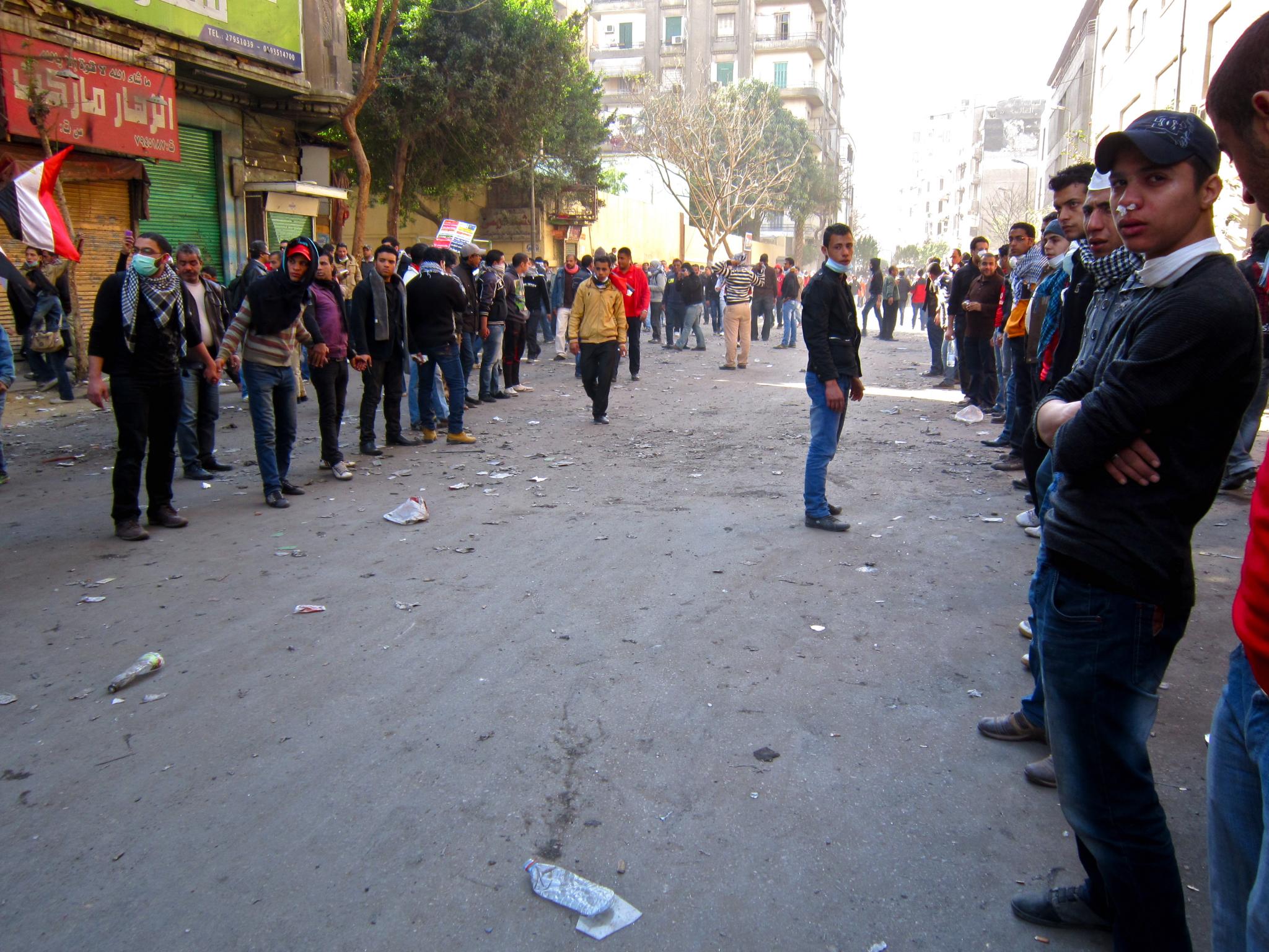 men walking down an empty street on the other side of people