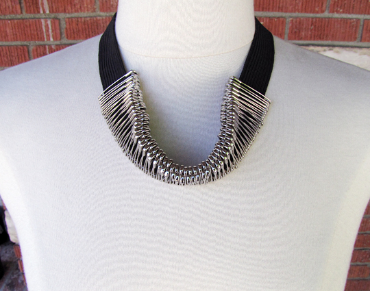 a collared black and white necklace sits on a mannequin