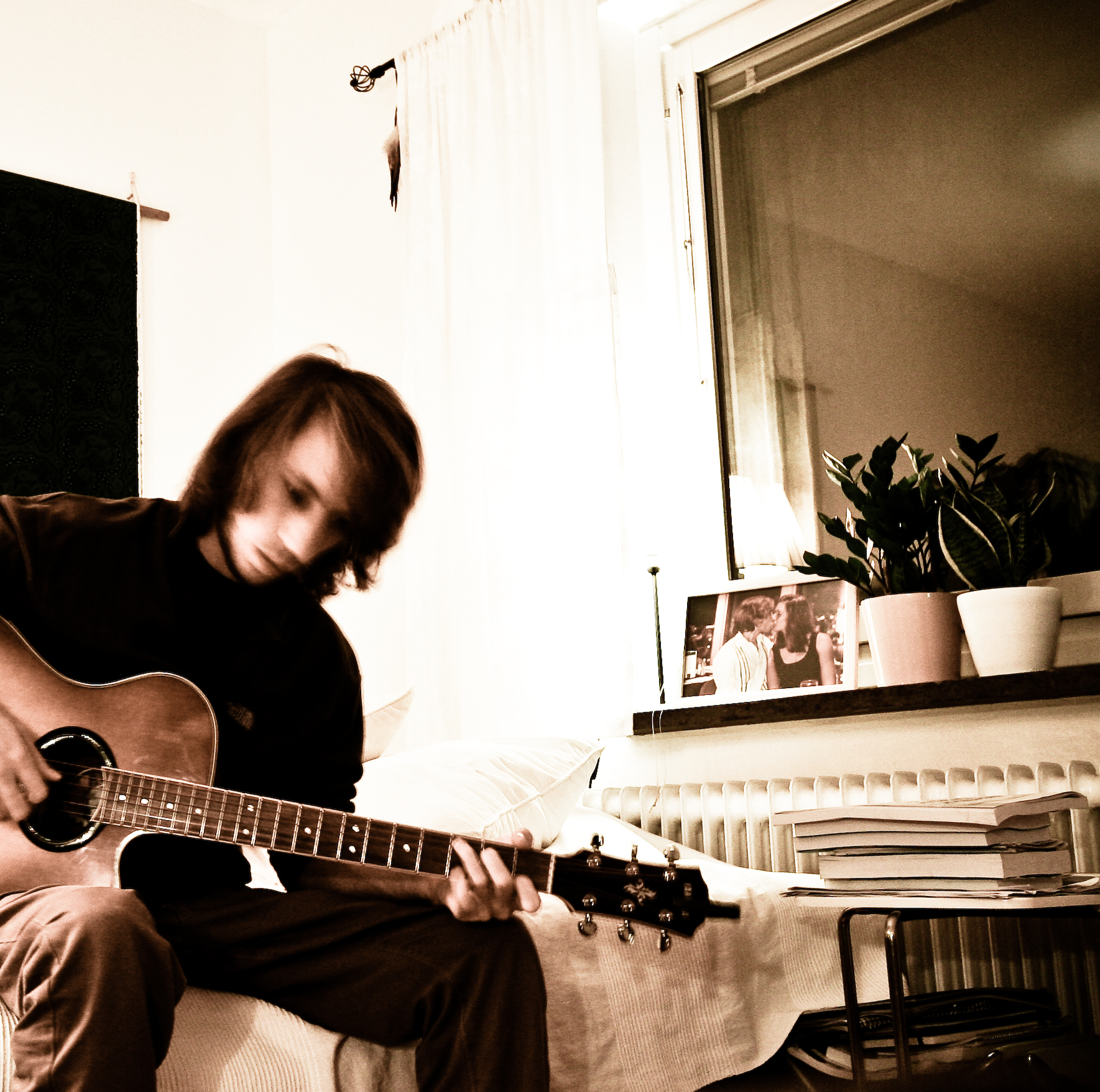 a man sitting on a couch holding a guitar
