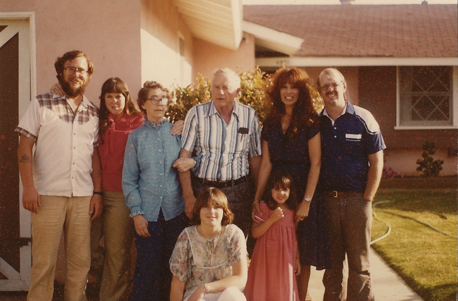 a family posing together outside a house