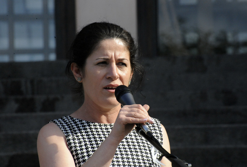 a woman wearing a black and white dress standing with a microphone