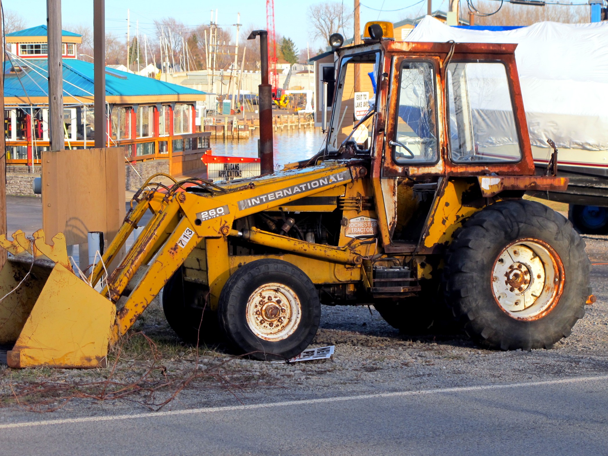 an old bulldozer on a street by a bus