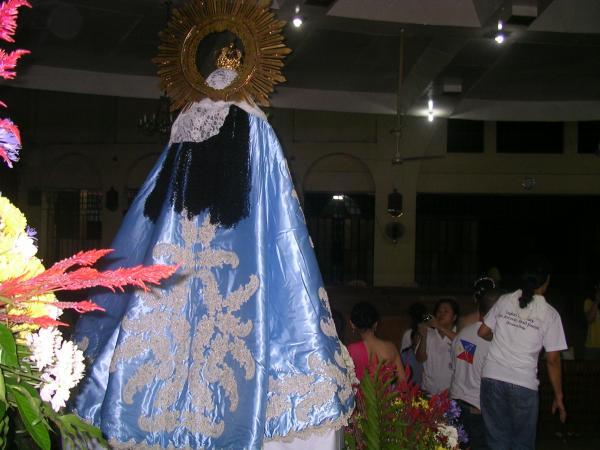 a statue with blue dress and golden mirror in the background