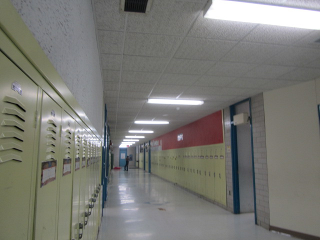 several rows of yellow lockers in a large hallway