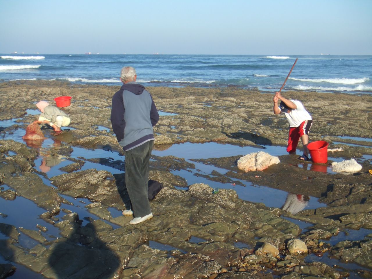 people playing with shovels on an empty beach