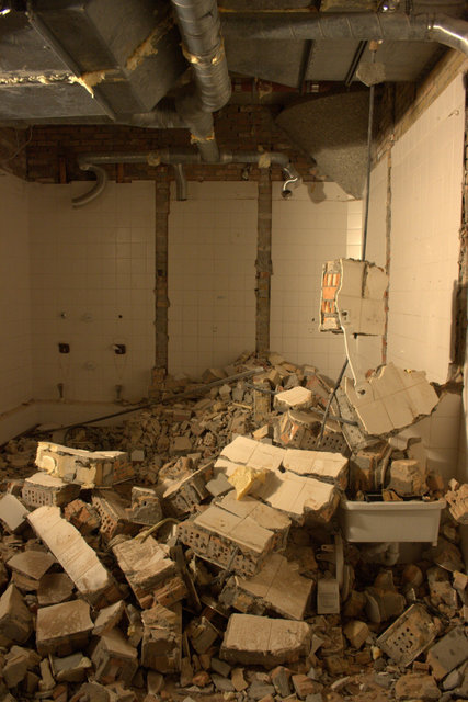 a bathroom is strewn with rubble in the day time