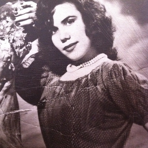 an old po shows a woman holding a bunch of flowers