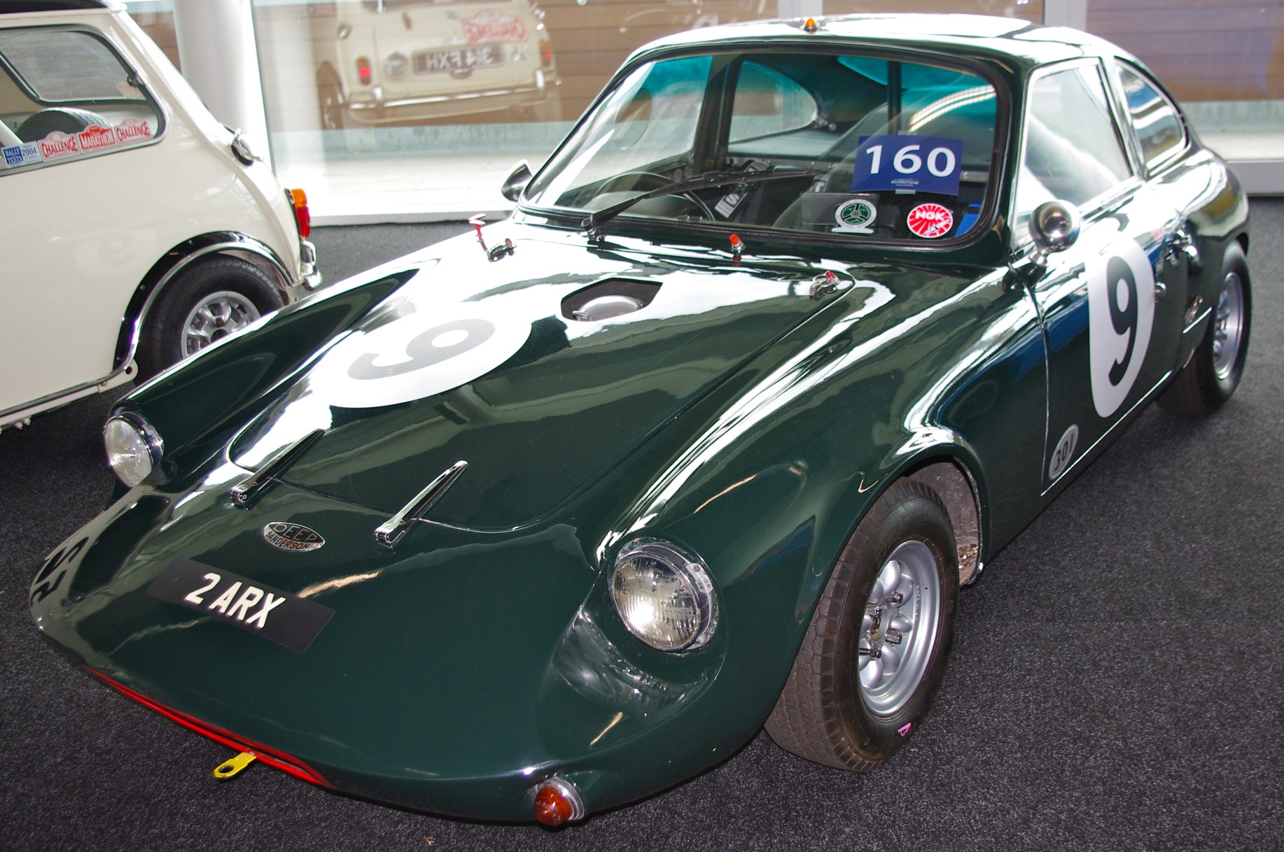 a green sports car on display at an antique show