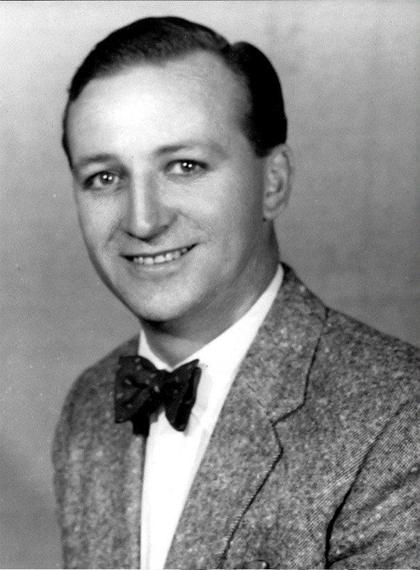 a man wearing a bow tie and suit posing for a po