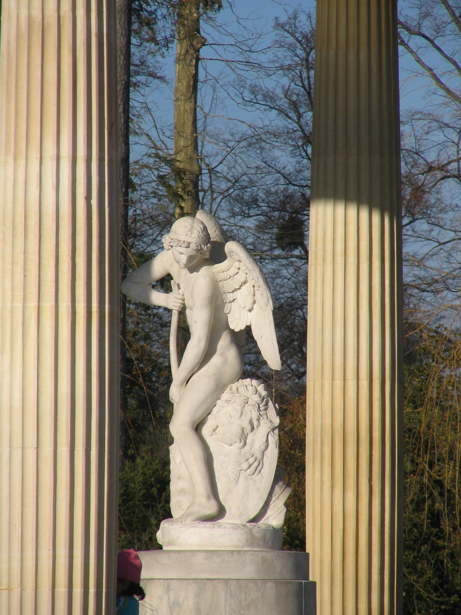 a statue is standing on an pedestal next to some pillars