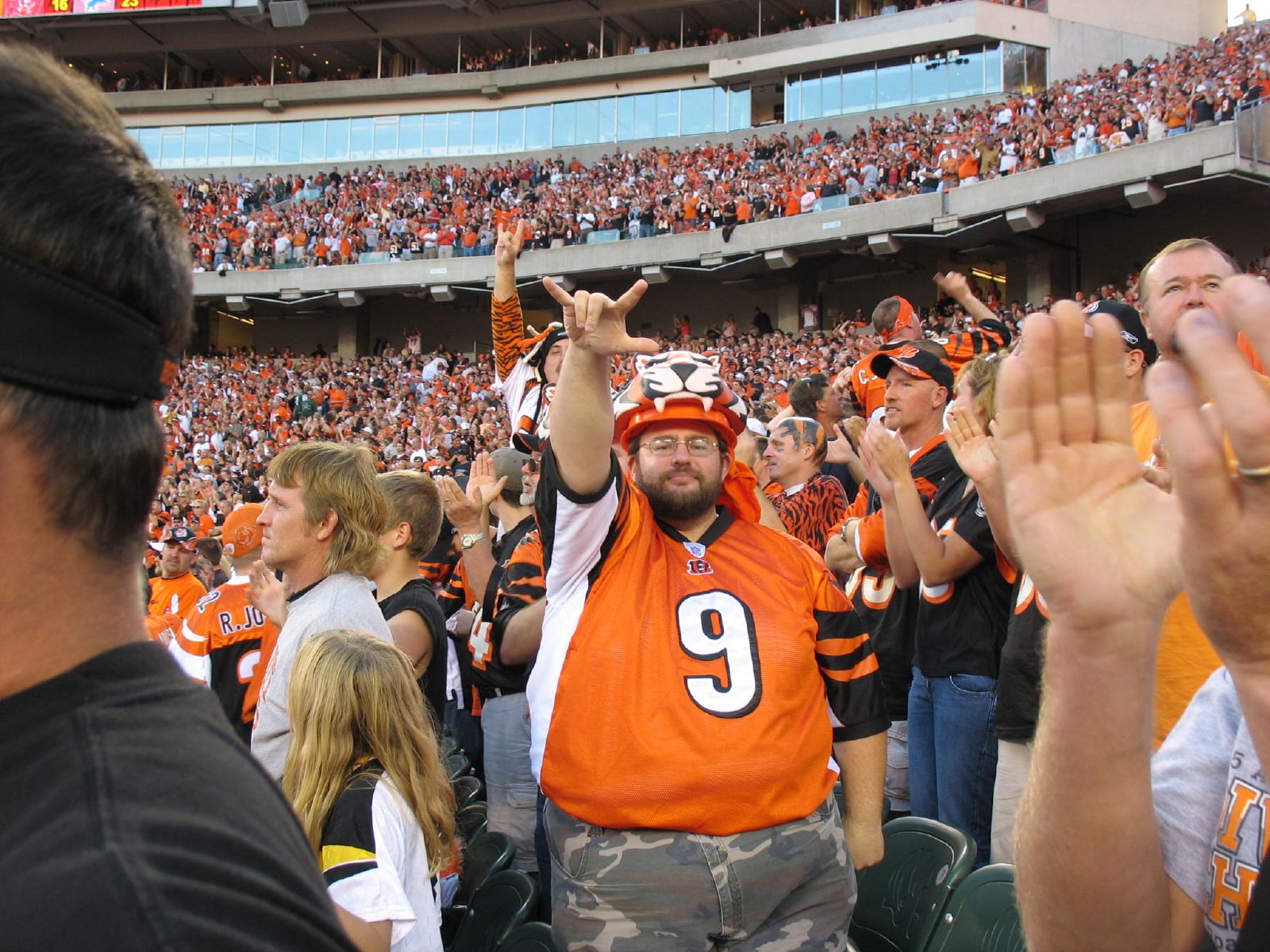 a football fan is at a game waving and clapping
