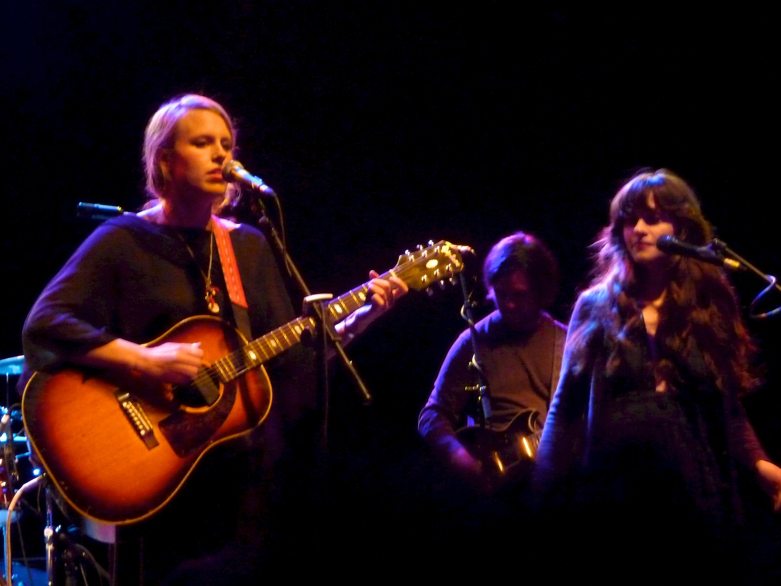 a man and woman on stage with guitars