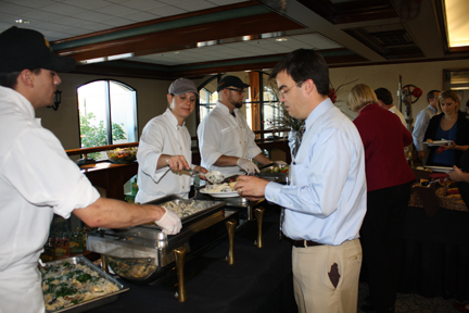 some men getting food at a buffet table