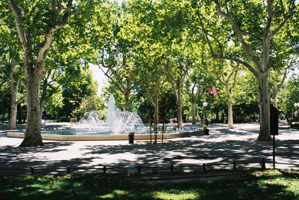 a park with a fountain and several trees on it