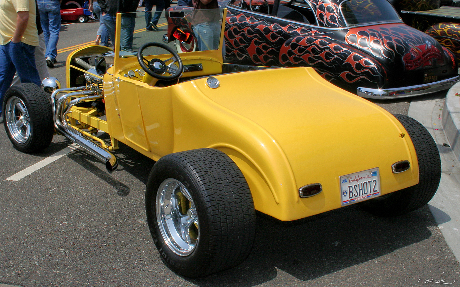 a close up of an older yellow car with others near by