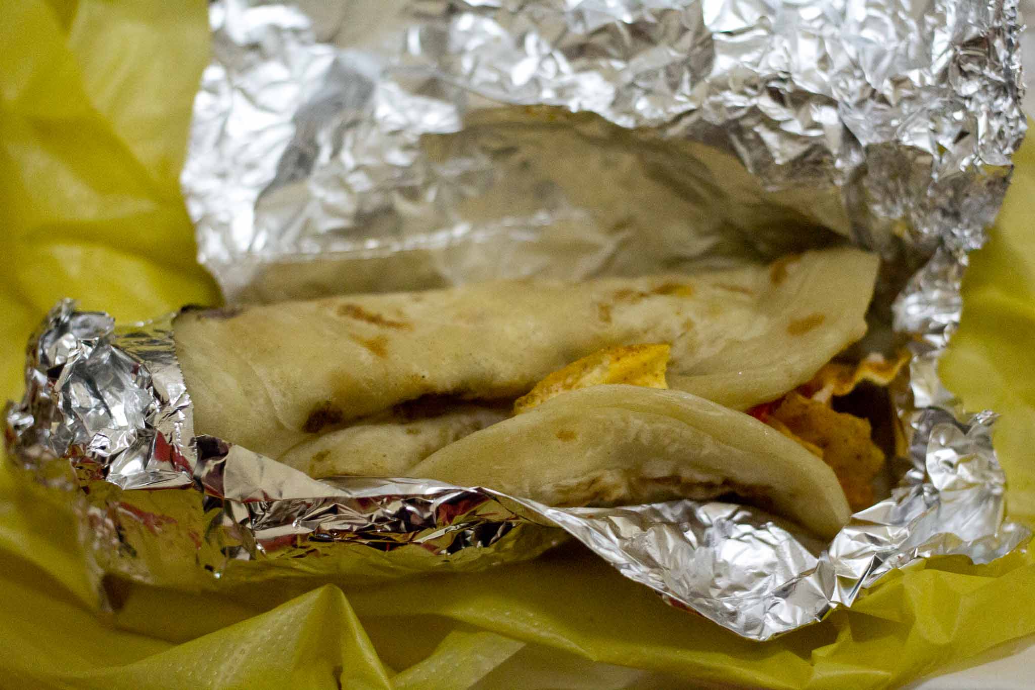 this taco has been wrapped in foil and ready to be eaten