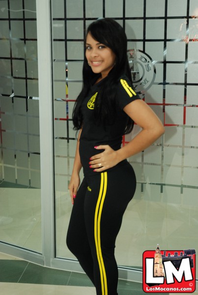 a woman with black hair wearing all black and yellow stripes