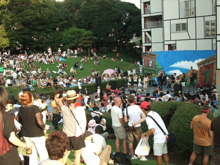 crowd of people gathered together and sitting on the grass