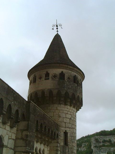 a tall stone castle has a clock on the tower