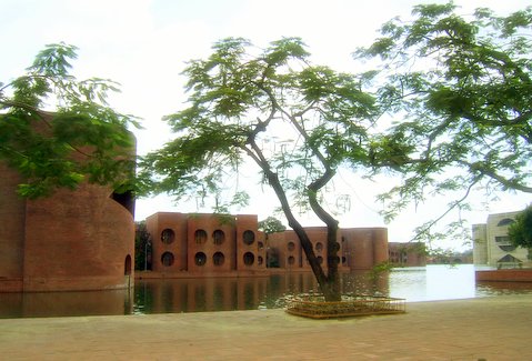 a fountain next to the water surrounded by red brick buildings