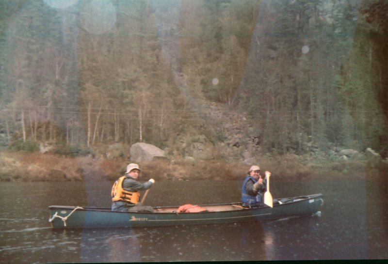 two men paddling in a canoe on the water