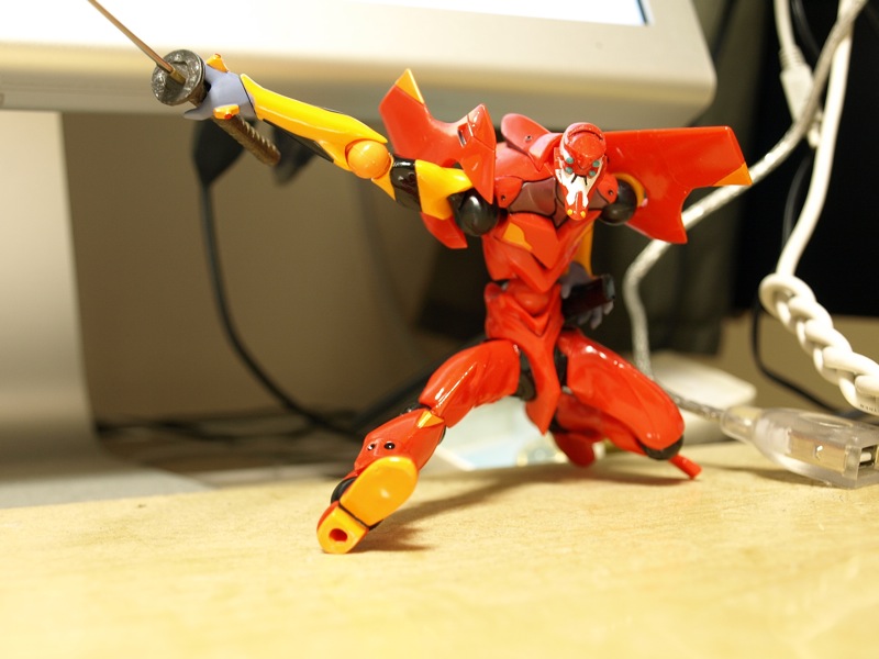 a red and yellow toy robot with a cord