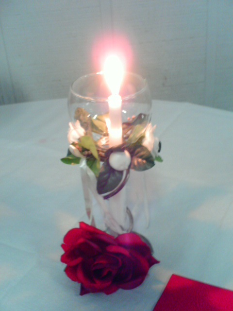 a rose and candles in a candle holder
