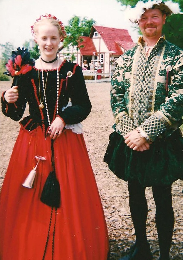 two people dressed in old fashion clothes smiling for the camera